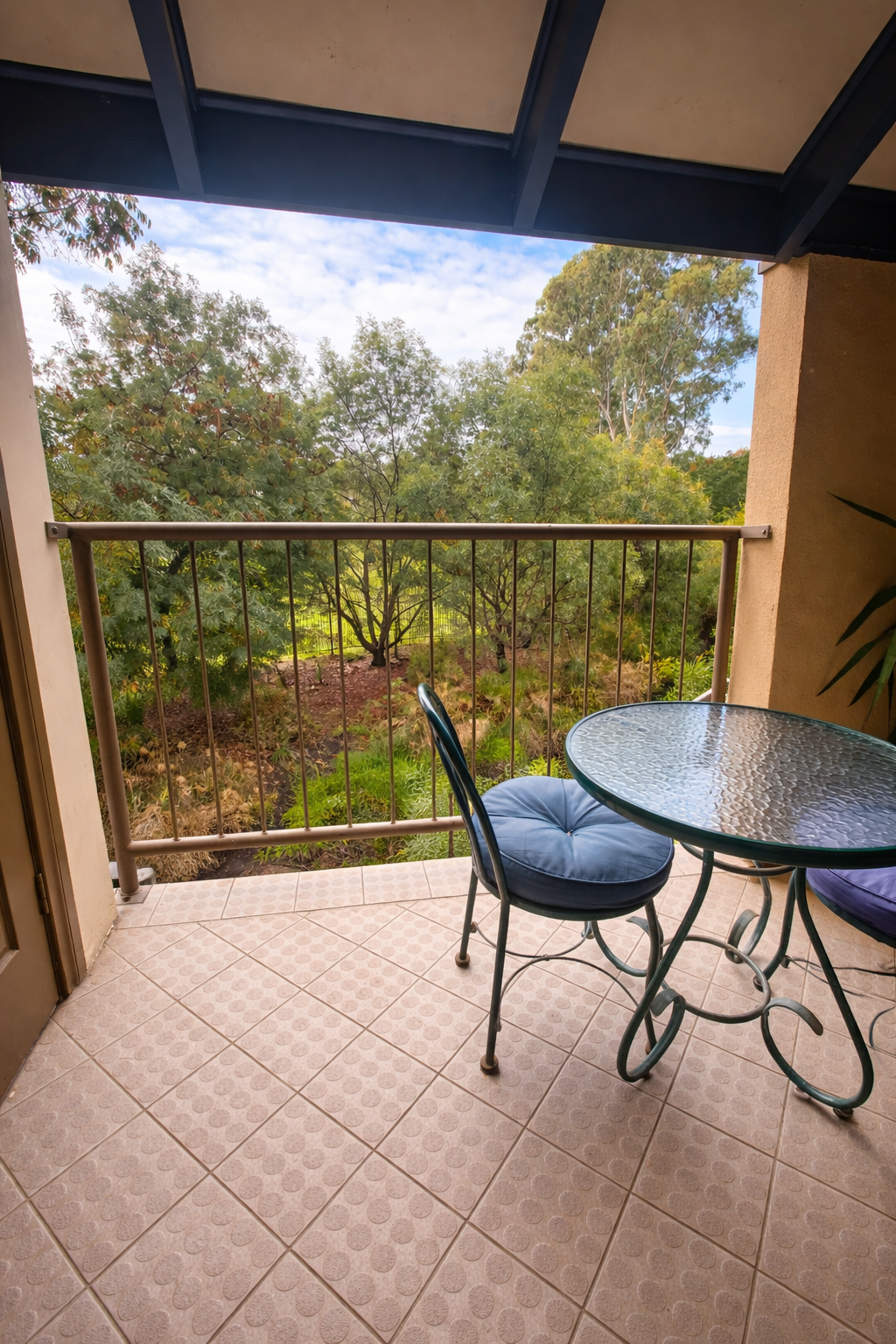 Private balcony with table and chairs overlooking the treetops