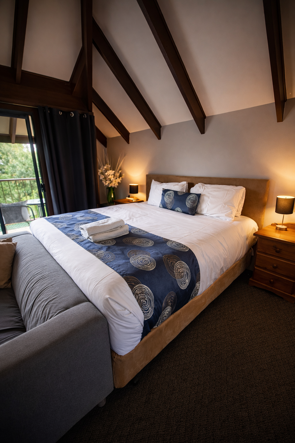 Spacious room with vaulted timber ceilings, king bed and garden-view balcony