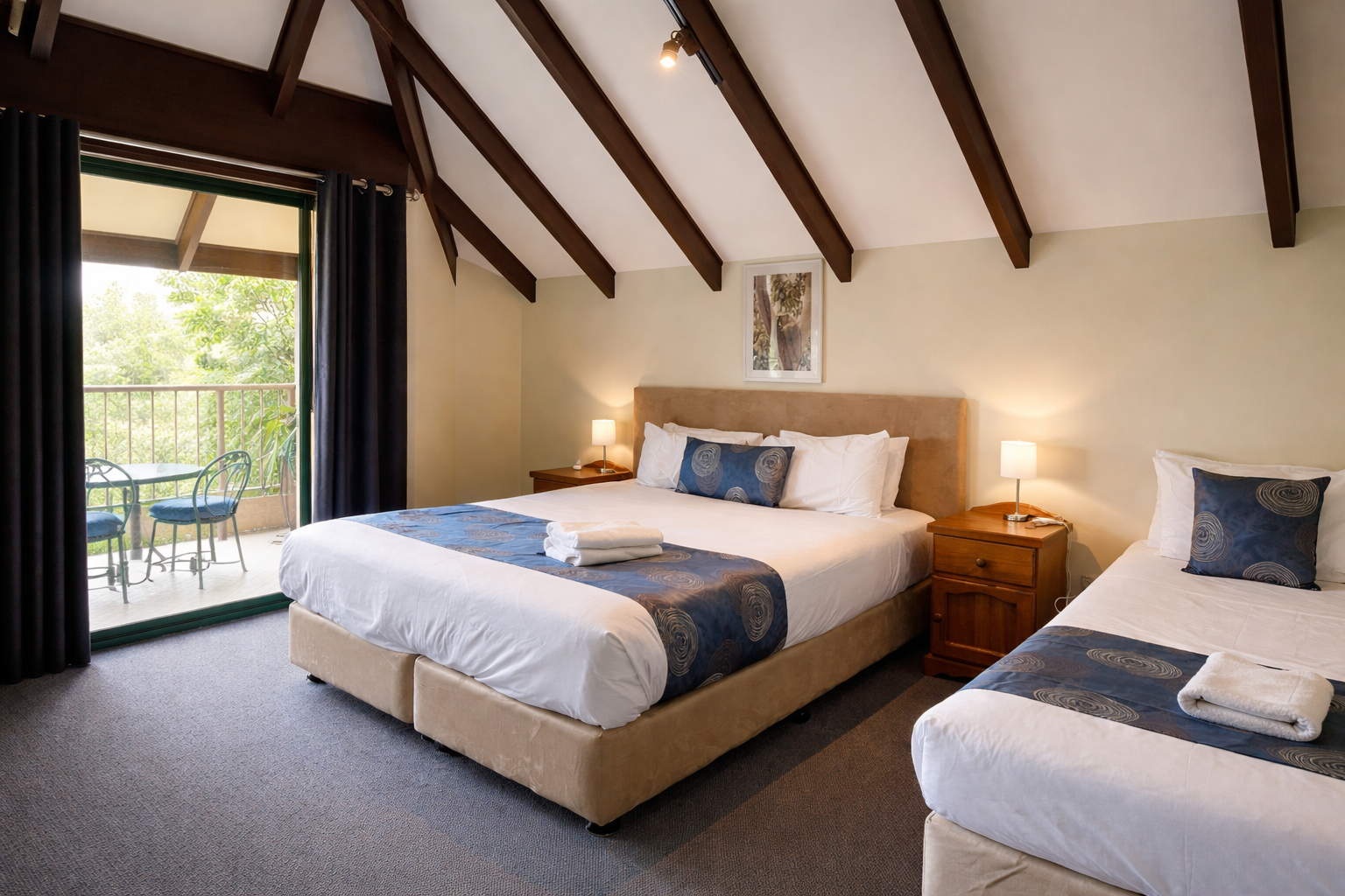 Twin room with queen and single beds opening onto a private balcony
